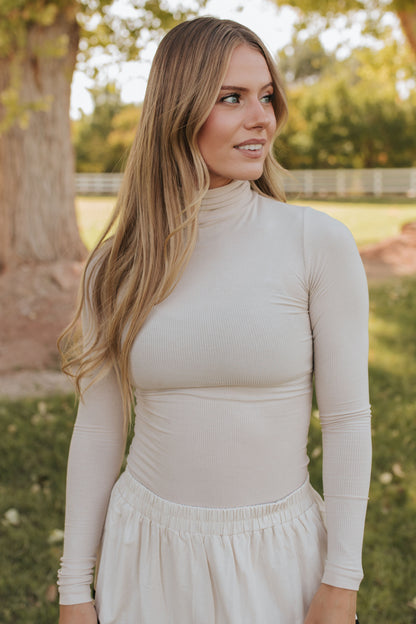 THE CONNER RIBBED TURTLENECK IN TAUPE